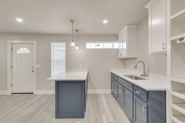 kitchen with gray cabinetry, light hardwood / wood-style floors, sink, and white cabinets