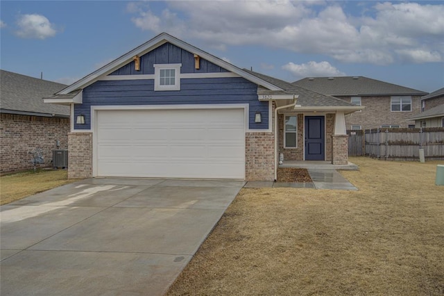 view of front of house featuring a garage, cooling unit, and a front lawn