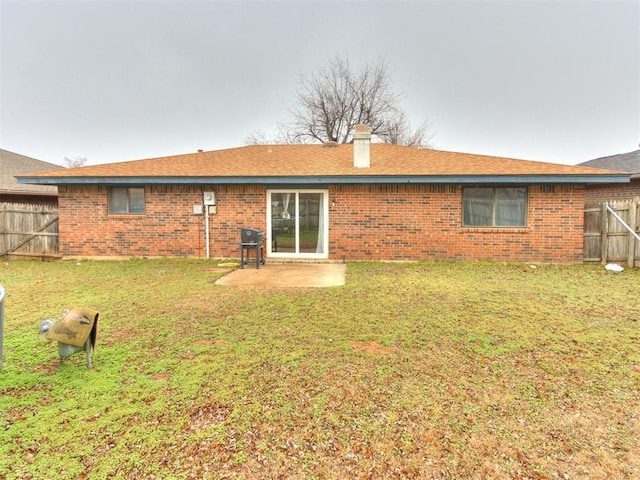 back of property with a lawn and a patio