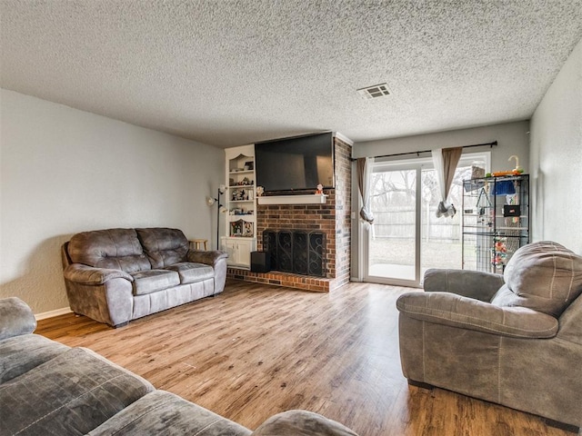 living room featuring hardwood / wood-style floors, a textured ceiling, and a fireplace