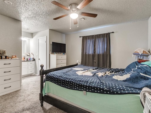 bedroom featuring ceiling fan, light carpet, and a textured ceiling