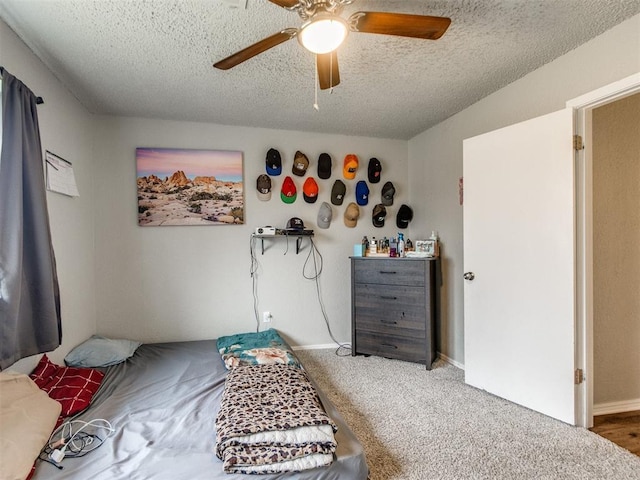 carpeted bedroom with ceiling fan and a textured ceiling