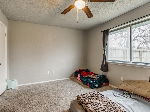 bedroom with carpet floors, a textured ceiling, and ceiling fan