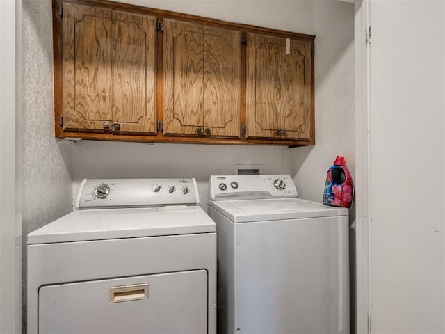 washroom featuring cabinets and separate washer and dryer