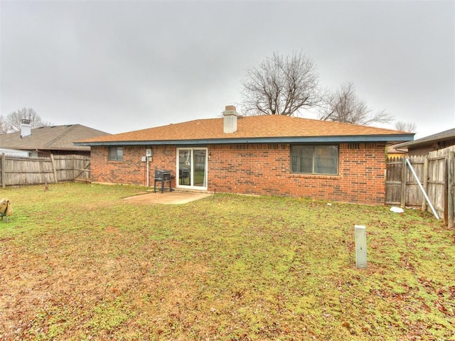 rear view of house featuring a yard and a patio