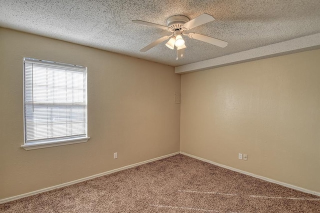 empty room with carpet flooring, a ceiling fan, baseboards, and a textured ceiling