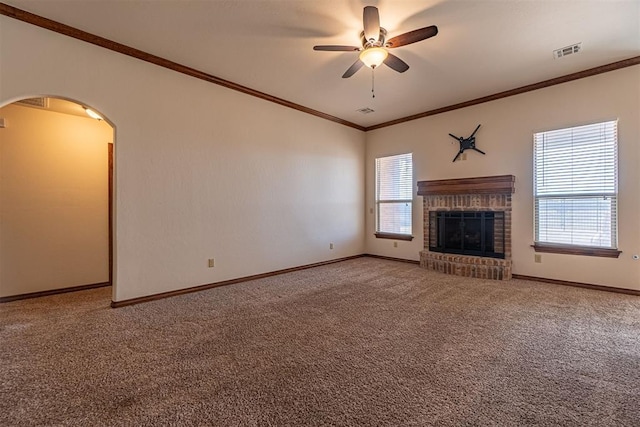 unfurnished living room with crown molding, carpet, a wealth of natural light, and a brick fireplace