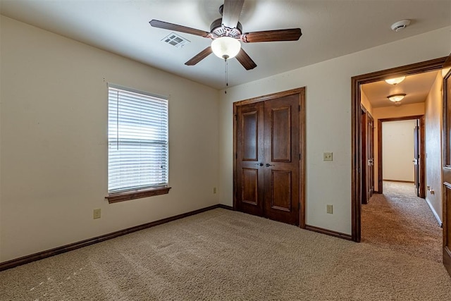 unfurnished bedroom featuring light carpet, ceiling fan, and a closet