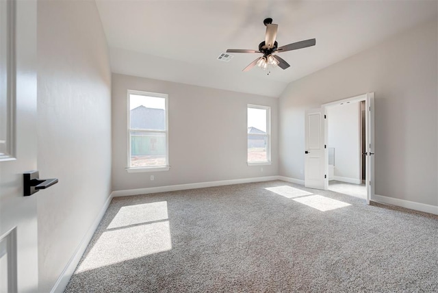 carpeted empty room with vaulted ceiling and ceiling fan