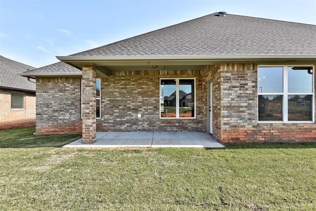 back of property with a yard and a patio