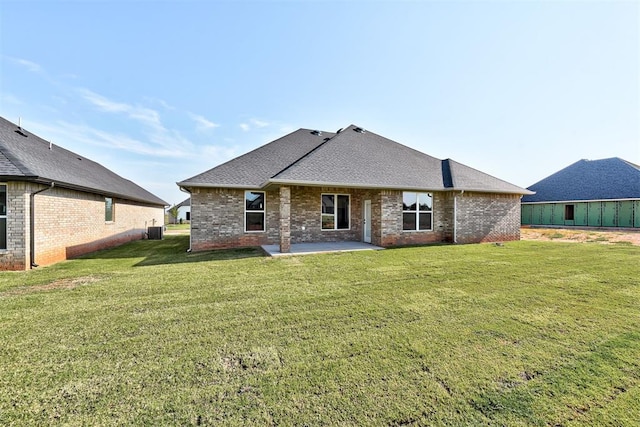 rear view of house with central AC, a patio area, and a lawn