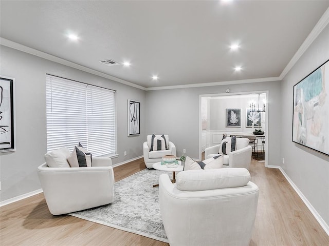 living room with ornamental molding and light hardwood / wood-style flooring