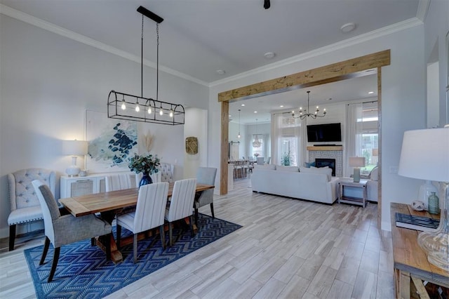 dining room with ornamental molding and light hardwood / wood-style flooring