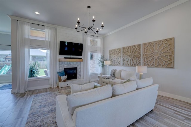 living room with light hardwood / wood-style flooring, a wealth of natural light, and ornamental molding