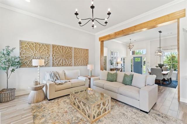 living room with crown molding, an inviting chandelier, and light hardwood / wood-style floors