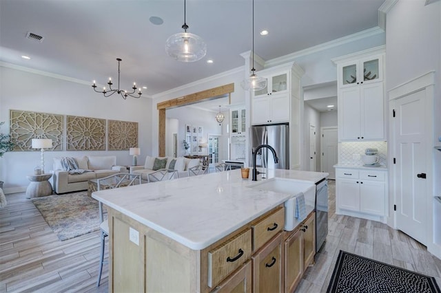 kitchen featuring a kitchen island with sink, white cabinetry, and appliances with stainless steel finishes