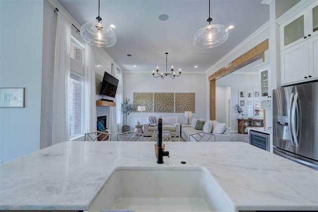 kitchen with a center island with sink, pendant lighting, and white cabinets