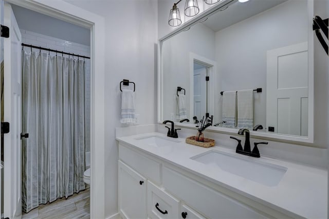 bathroom featuring vanity, toilet, a shower with shower curtain, and hardwood / wood-style floors