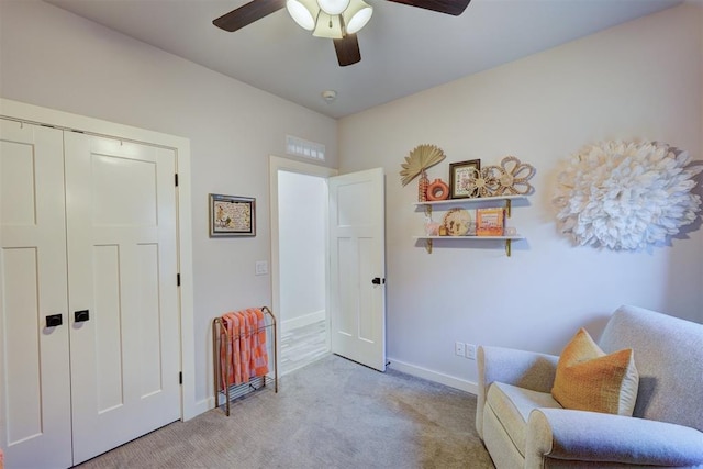 sitting room with ceiling fan and light carpet