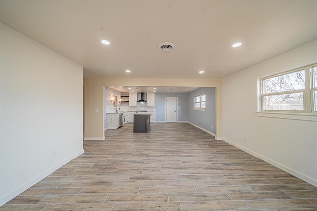 unfurnished living room with sink and light hardwood / wood-style flooring