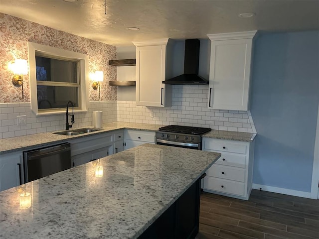 kitchen featuring white cabinetry, black dishwasher, sink, light stone countertops, and wall chimney range hood