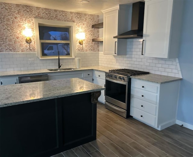 kitchen with sink, white cabinetry, stainless steel range with gas stovetop, dishwasher, and wall chimney range hood