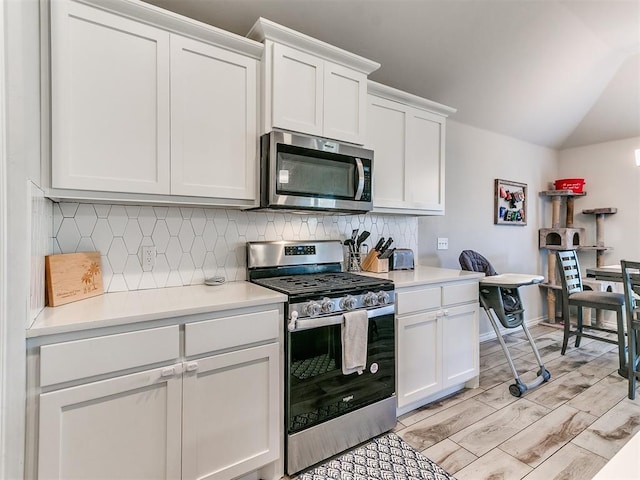 kitchen featuring tasteful backsplash, light hardwood / wood-style flooring, stainless steel appliances, and white cabinets