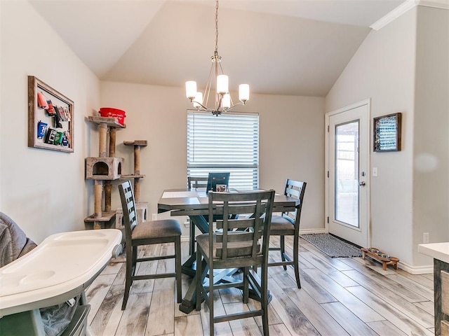 dining area with vaulted ceiling, a notable chandelier, and light hardwood / wood-style floors