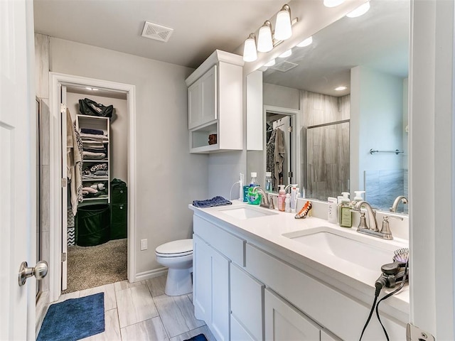 bathroom featuring vanity, toilet, and a shower with shower door