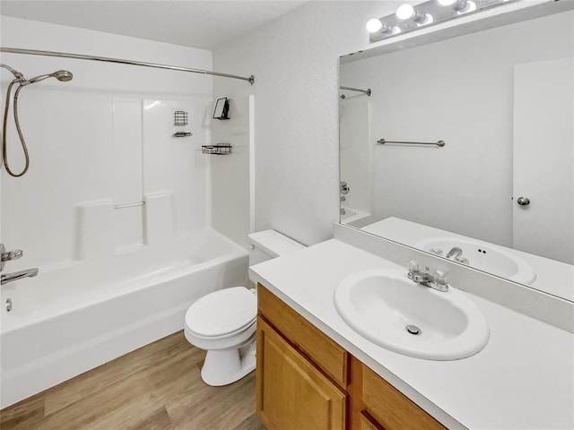 full bathroom featuring hardwood / wood-style flooring, vanity, tub / shower combination, and toilet