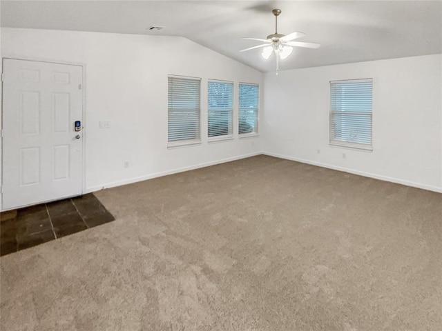 interior space with vaulted ceiling, ceiling fan, and dark carpet