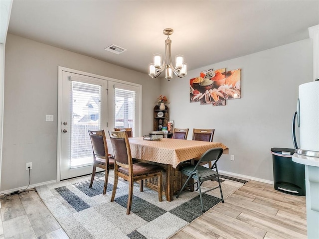 dining room featuring a chandelier and light wood-type flooring