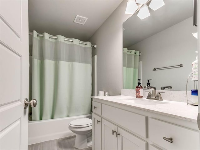 full bathroom with shower / tub combo with curtain, vanity, and toilet