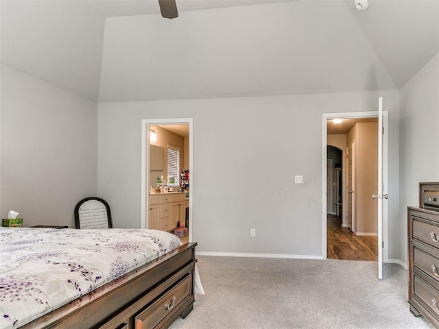 bedroom featuring vaulted ceiling, light carpet, and ensuite bathroom