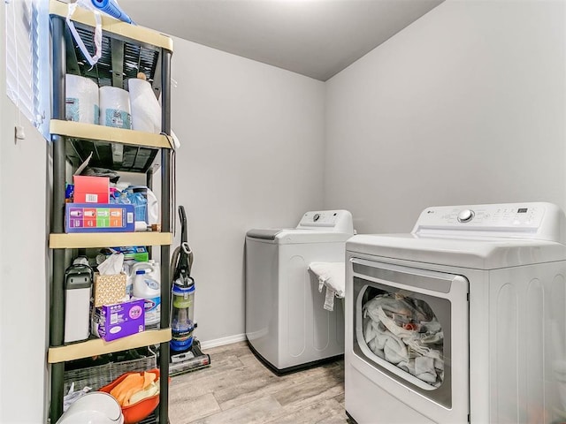 laundry room featuring washing machine and clothes dryer and light wood-type flooring