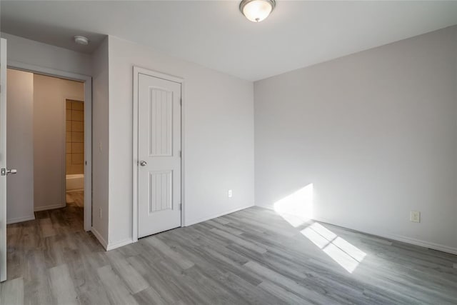 unfurnished bedroom with a closet and light wood-type flooring