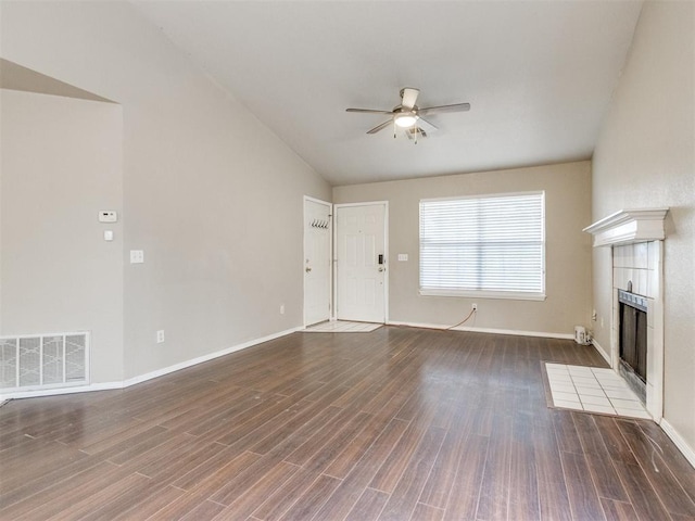 unfurnished living room featuring a fireplace, dark hardwood / wood-style floors, ceiling fan, and vaulted ceiling