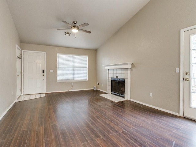 unfurnished living room featuring wood-type flooring, a tile fireplace, and a wealth of natural light