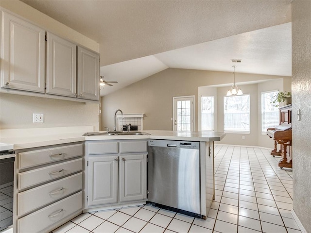 kitchen featuring sink, decorative light fixtures, vaulted ceiling, stainless steel dishwasher, and kitchen peninsula