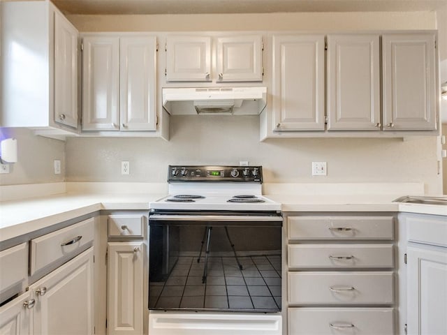 kitchen with white cabinetry, range with electric stovetop, and tile patterned floors