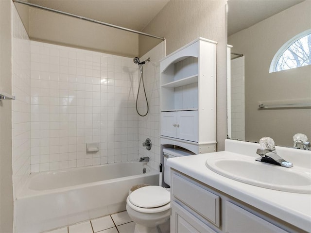 full bathroom with tile patterned flooring, vanity, tiled shower / bath combo, and toilet