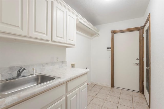 kitchen featuring light tile patterned flooring, sink, and white cabinets