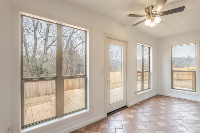 doorway to outside featuring ceiling fan and plenty of natural light