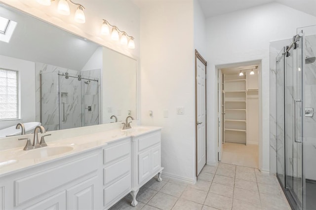 bathroom with vanity, a shower with shower door, tile patterned floors, and vaulted ceiling with skylight