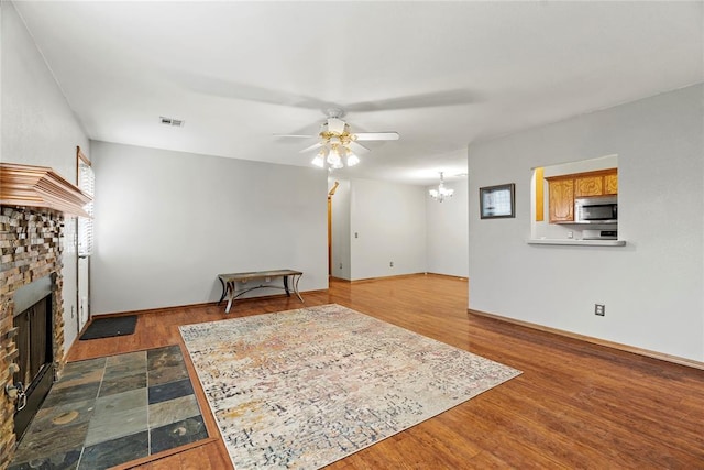 living room featuring ceiling fan with notable chandelier and hardwood / wood-style floors