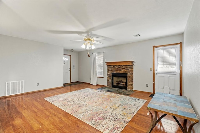 living room featuring hardwood / wood-style flooring, a fireplace, and ceiling fan