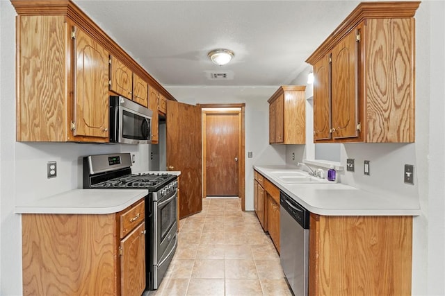 kitchen with sink, light tile patterned flooring, and appliances with stainless steel finishes