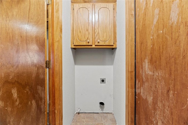 washroom featuring cabinets, electric dryer hookup, and light tile patterned floors