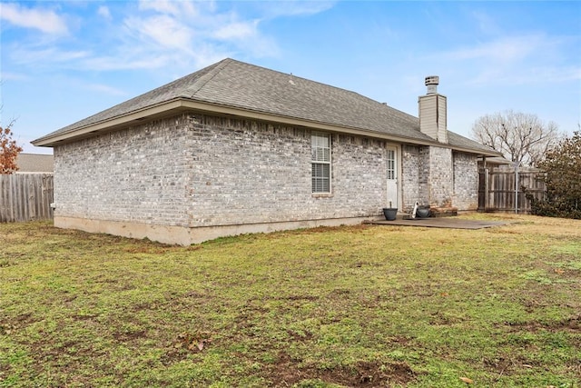 view of side of property with a yard and a patio