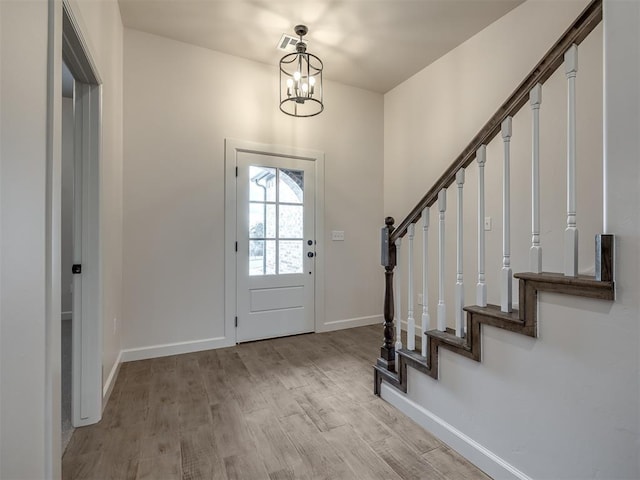 entrance foyer with light hardwood / wood-style floors and a chandelier